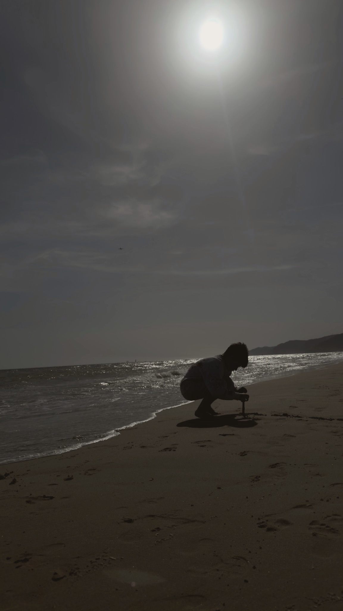 Silueta de un niño jugando en la orilla del mar